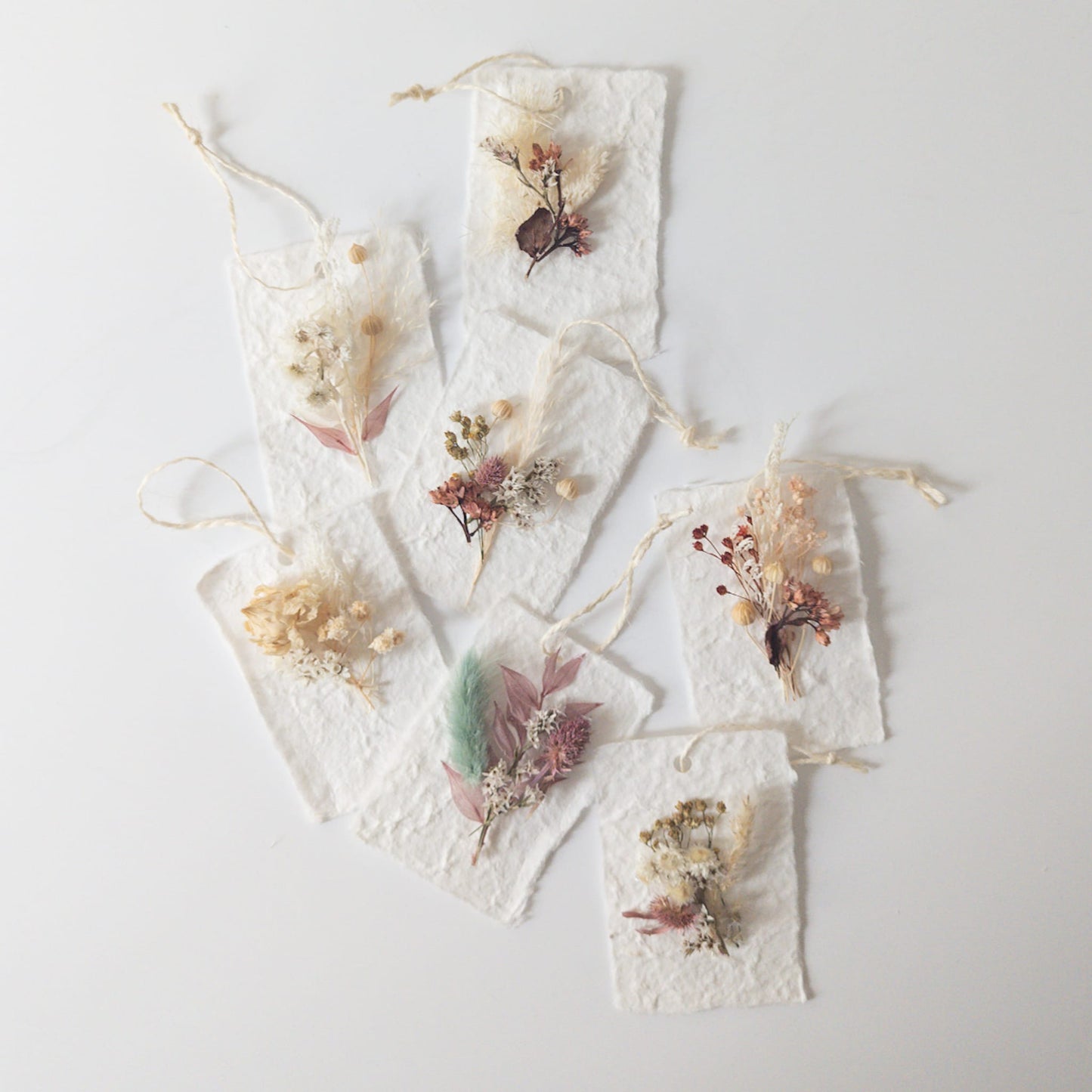 Handmade dried flower gift tags arranged on a table
