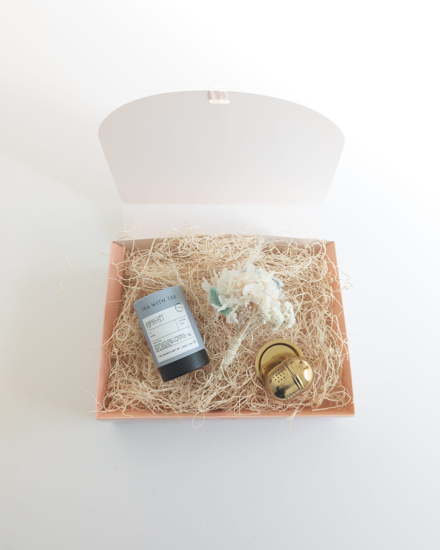 Luxury boutique items packaged in a foldable gift box with tissue paper