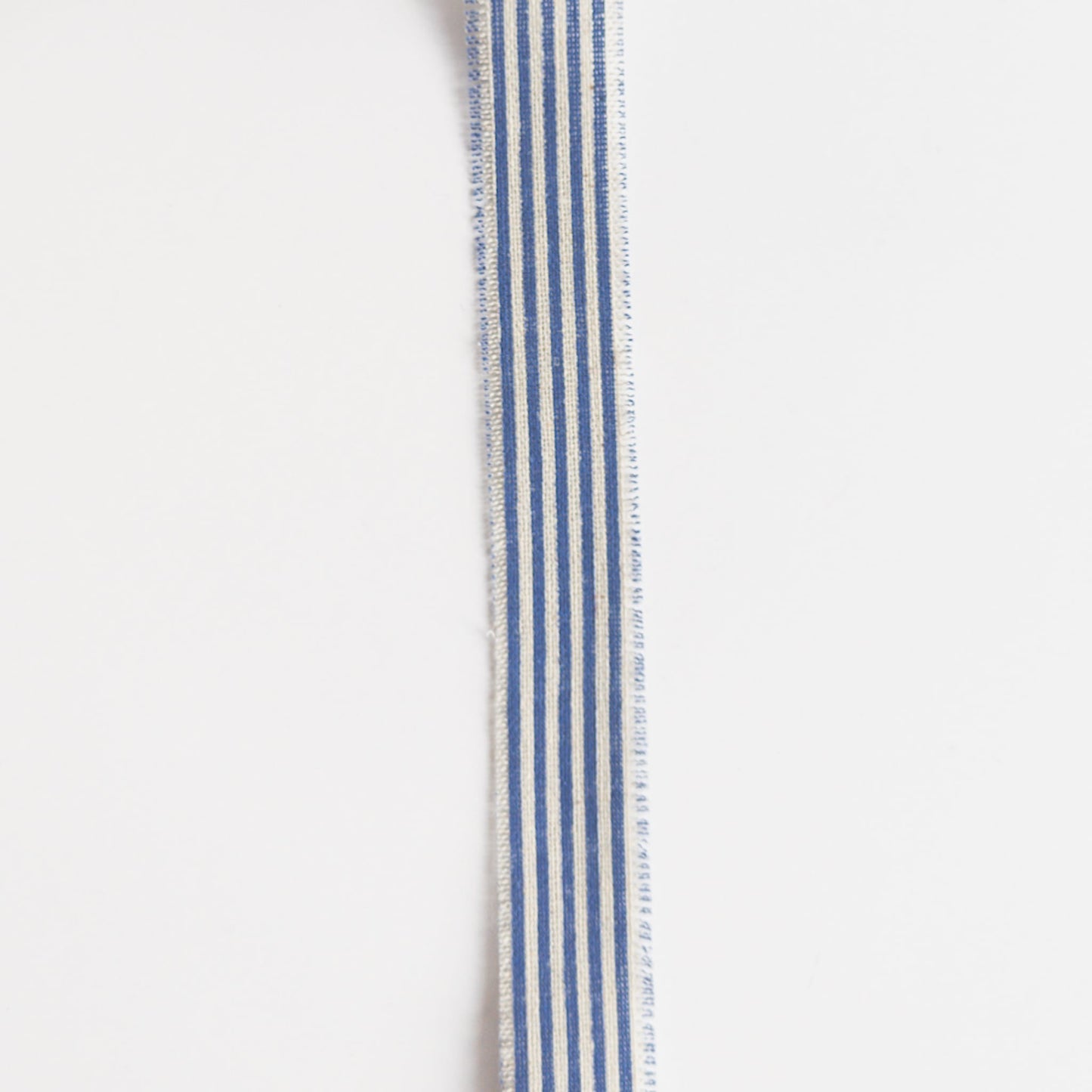 Natural linen ribbon with blue stripes on a spool, rustic aesthetic
