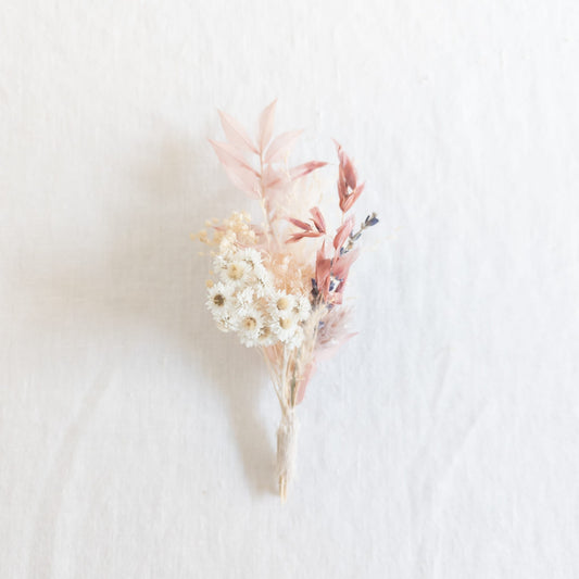Mini bud vase bouquet with delicate flowers on a linen fabric background