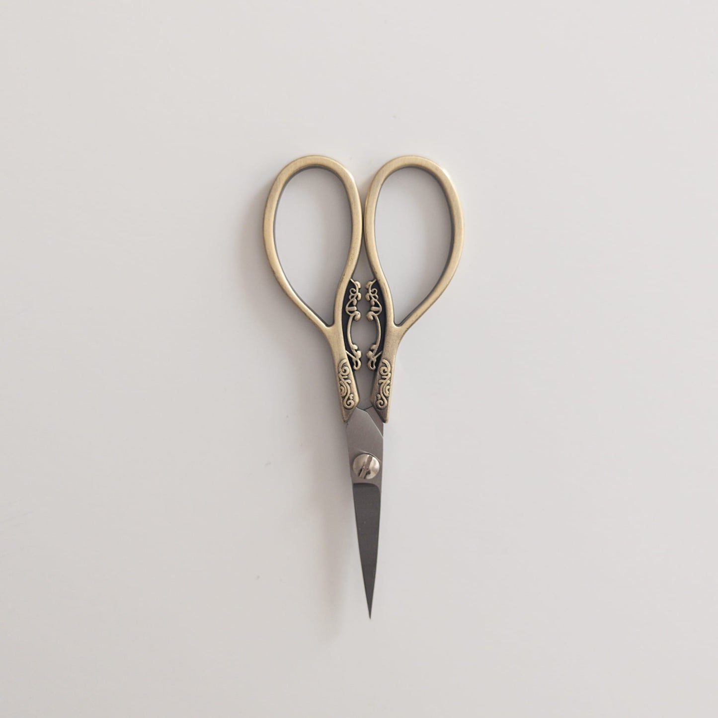 Close-up of antique-inspired scissors cutting ribbon for gift wrapping

