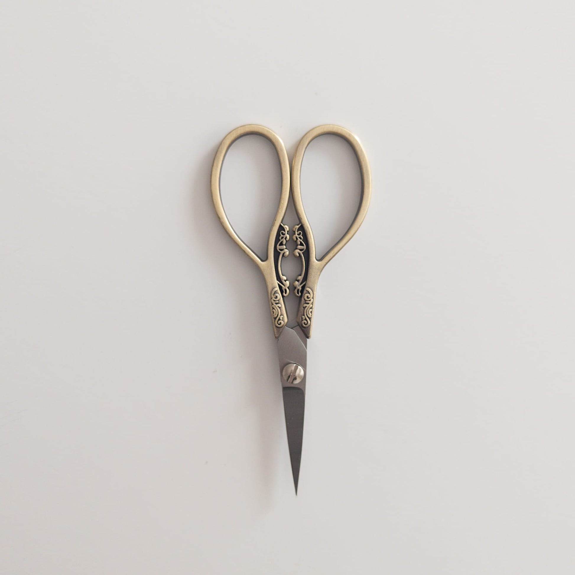 Close-up of antique-inspired scissors cutting ribbon for gift wrapping
