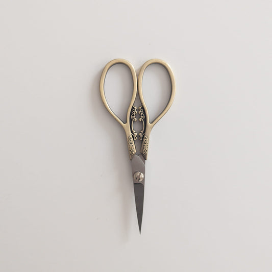 Close-up of antique-inspired scissors cutting ribbon for gift wrapping
