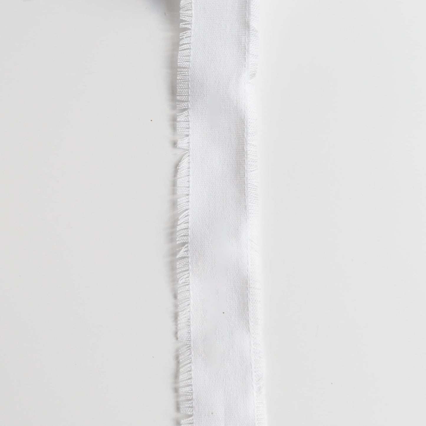 Floral arrangement wrapped with soft linen ribbon in neutral tones
