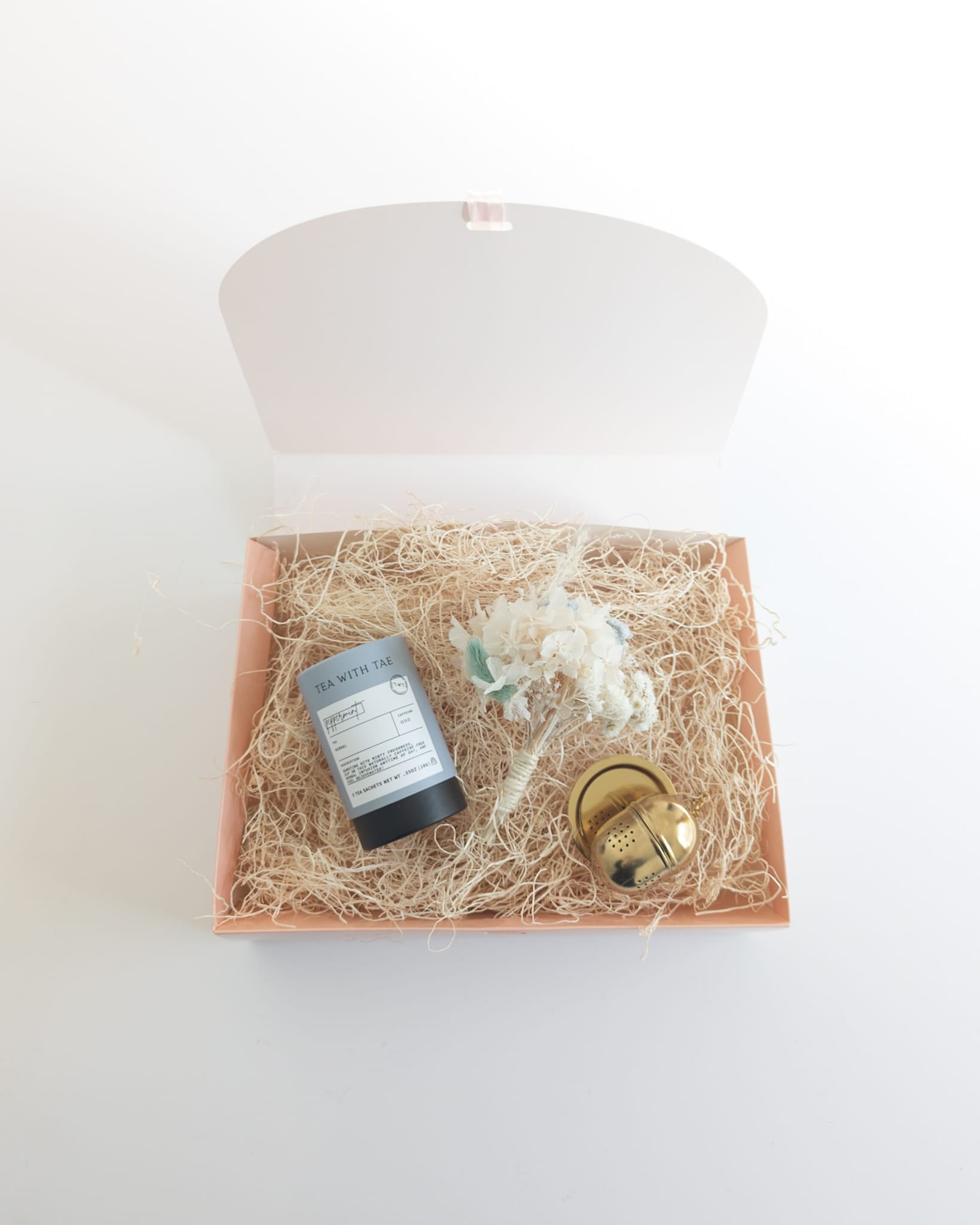Luxury boutique items packaged in a foldable gift box with tissue paper